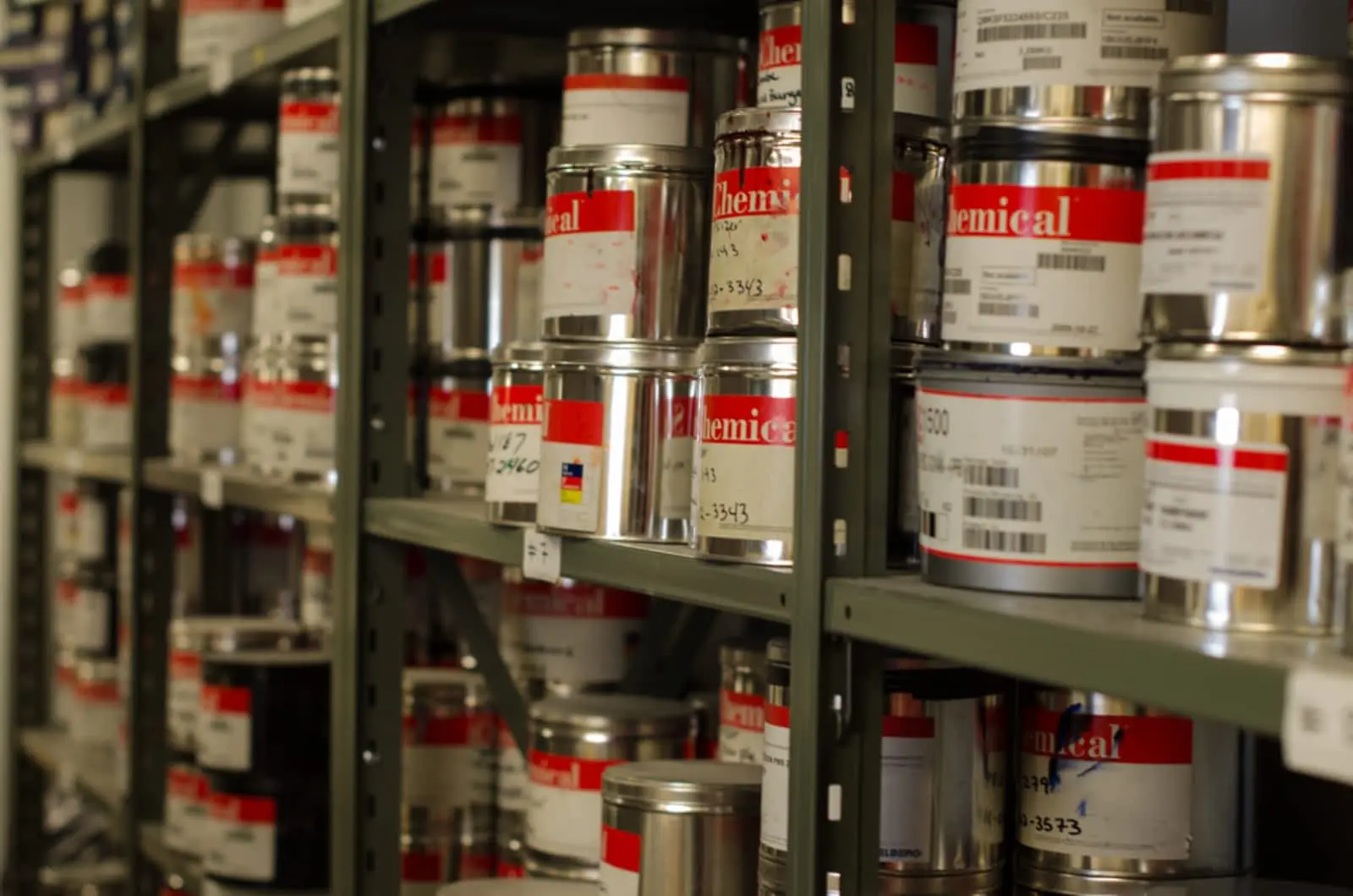 Ink cans lined up on metal shelves.