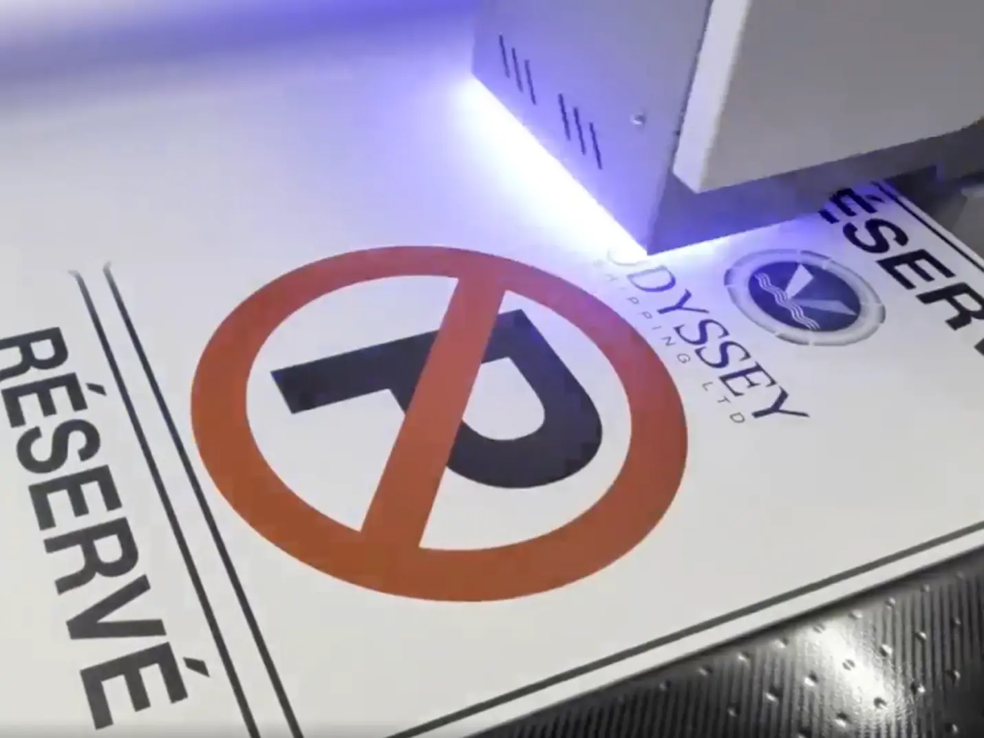 A reserved parking sign under the print head of a flatbed printer