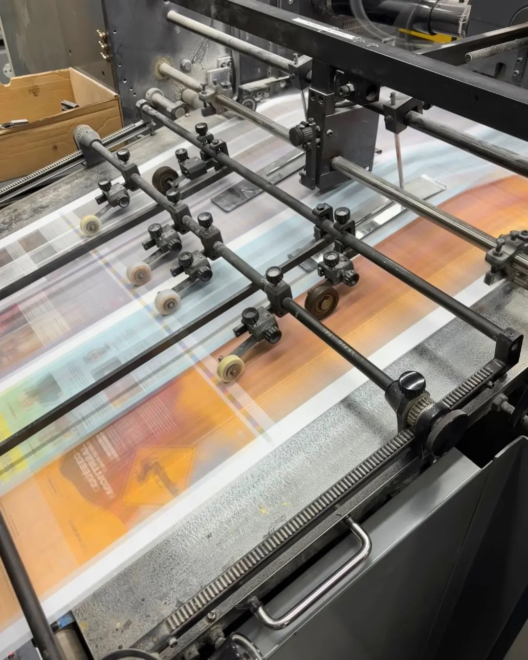 Printed colour sheets running under the guides of a press.